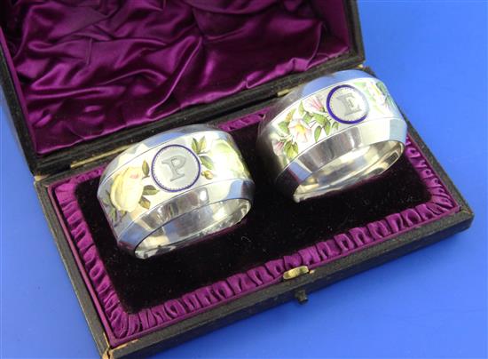 A cased pair of Victorian silver and enamel napkin rings, 2in.